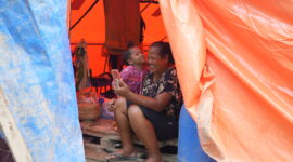Seorang ibu dan anak memanfaatkan layanan telekomunikasi pascabencana di Sumatra.