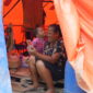 Seorang ibu dan anak memanfaatkan layanan telekomunikasi pascabencana di Sumatra.